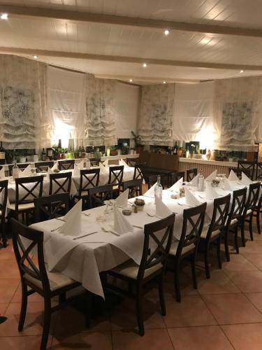路德维希堡Westend Hotel的宴会厅配有白色桌椅和白色餐巾