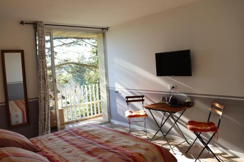 屈屈龙les 3 saisons的一间卧室配有一张床、一张桌子和一个窗户。