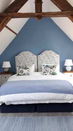 昂比La Ripaudière的一间卧室配有一张带蓝色墙壁的大床