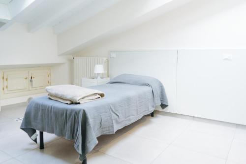 布雷西亚LUOGO COMUNE Ostello的白色卧室配有床和桌子