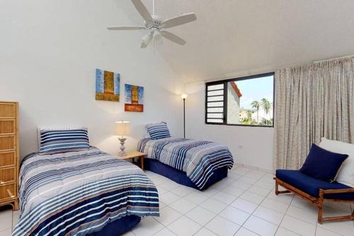 乌马考Beach Villa 233的一间卧室设有两张床、一把椅子和一个窗户。