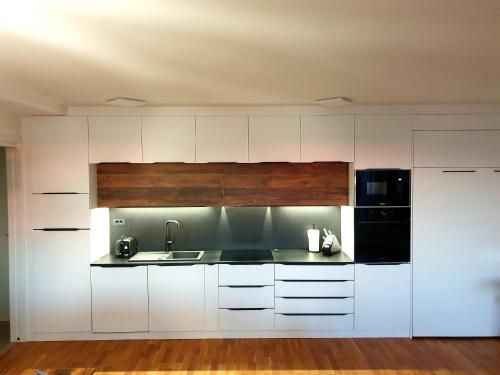 科佩尔Apartment Polonia的厨房配有白色橱柜和黑色用具
