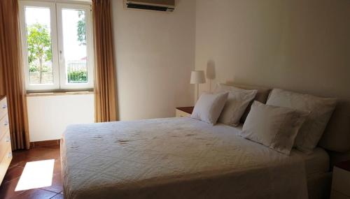 罗维尼ARIANNA MARE Rooms的一间卧室配有一张带白色床单的床和一扇窗户。
