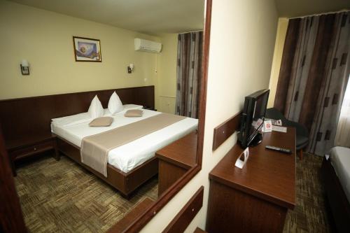 斯洛博齐亚Hotel Select Slobozia的酒店客房,配有床和镜子