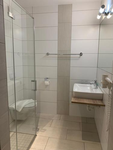 兰克韦尔大洋酒店的一间带水槽和玻璃淋浴的浴室