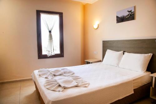 达特恰Beyaz Konak Evleri的一间卧室配有一张带白色床单的床和一扇窗户。