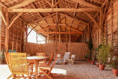 Montesquieu-VolvestreGîte rural Aqui-naut的木制谷仓,配有桌椅