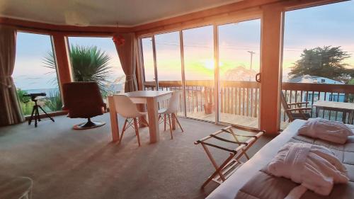 努盖特角Kaka Point Spa Accommodation - Catlins的配有一张床和一张桌子及椅子的房间