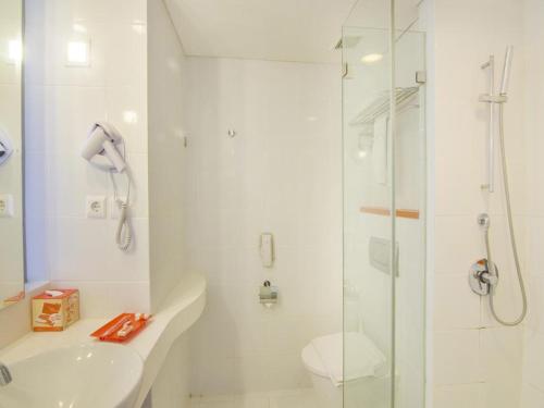 登巴萨登巴萨哈里斯酒店的带淋浴、卫生间和盥洗盆的浴室