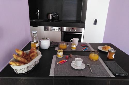 普罗旺斯艾克斯APPART AIX MAZARIN的一张桌子,上面放着一篮羊角面包和橙汁