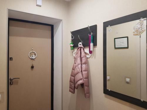 平斯克Пинск Brestskaia的走廊上设有一扇带粉红色围巾和时钟的门