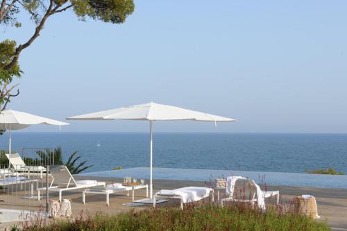 圣佩德罗-德里瓦斯Villa Casa del Mar的海滩上设有椅子和遮阳伞,还有大海