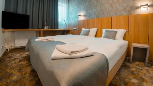 科希策Hotel Aréna的酒店客房带一张大床,带毛巾