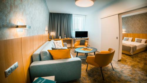 科希策Hotel Aréna的酒店客房设有沙发、床和桌子。