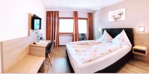 维辛Hotel Sonnhof的配有一张床和一张书桌的酒店客房