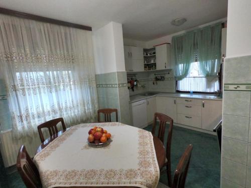 诺维萨德Moj salaš的厨房配有一张桌子,上面放着一碗水果