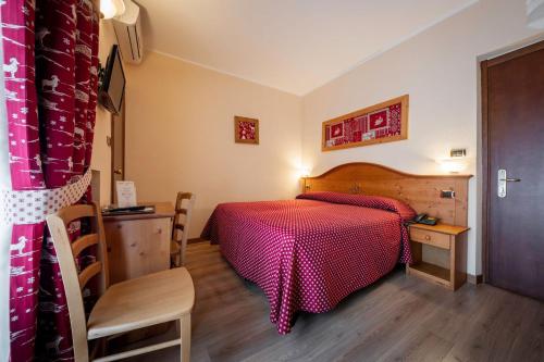 圣文森特艾琳娜酒店的一间卧室设有红色的床,铺有木地板。