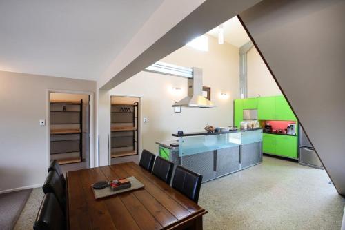 WaipiataTussock Lodge - Waipiata的一间带桌子的厨房和一间带绿色橱柜的厨房