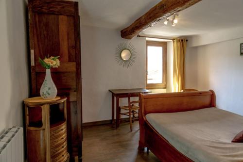 蒙布兰莱班Gîte Chambres d'hôtes Le Bellevue的一间卧室配有一张床和一张带花瓶的桌子