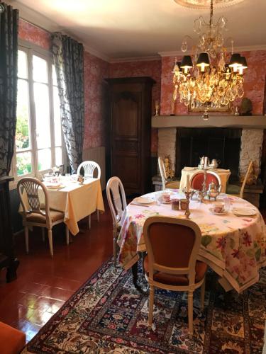 多维尔图尔热维尔狮子庄园酒店的一间带2张桌子和吊灯的用餐室