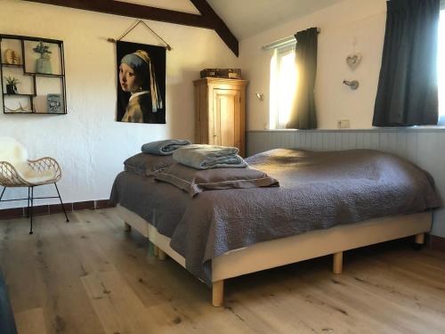 WezepDe Heidehoeve的卧室配有一张带女性绘画的床