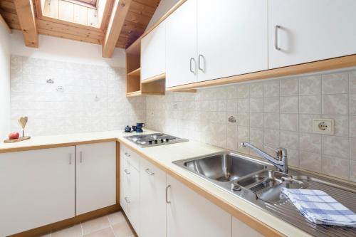 奥蒂塞伊Am Rainell Hof的厨房配有白色橱柜和水槽