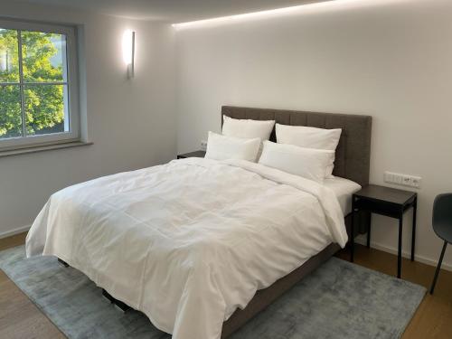 克赖尔斯海姆Toploft Serviced Apartments的卧室配有一张带白色床单和枕头的大床。