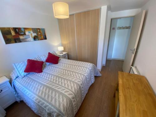 圣卡洛斯-德巴里洛切卡斯科和斯特瑞可公寓的一间卧室配有一张带两个红色枕头的床