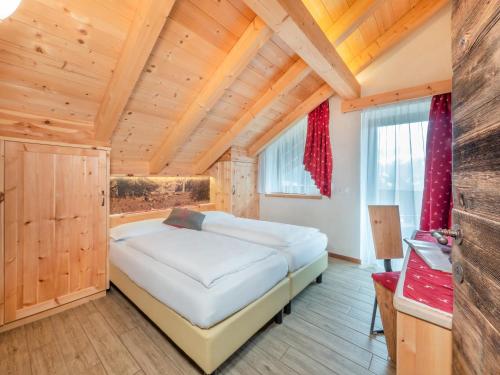 拉瓦莱卡萨劳特公寓的一间带一张大床的卧室,位于一个拥有木制天花板的房间