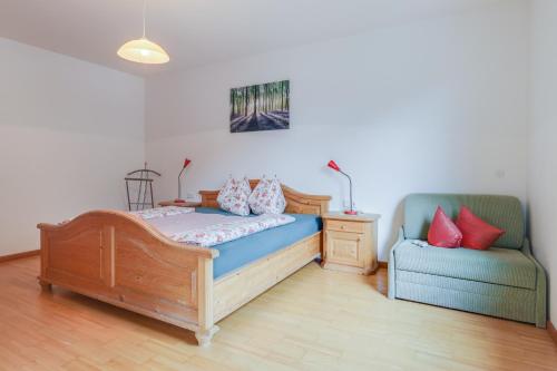 圣马蒂诺Kelderer Hof - Appartment Jaufen的一间卧室配有一张床和一张蓝色椅子