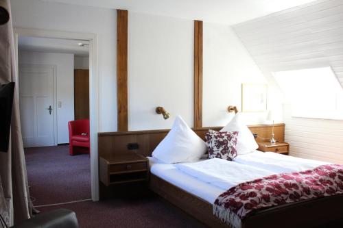 特里滕海姆加莱里斯林酒店的酒店客房,配有一张床和一张红色椅子
