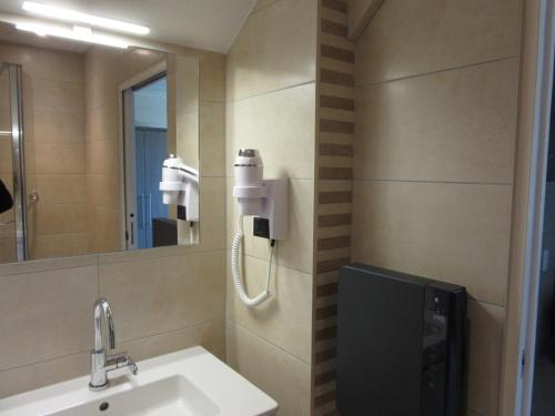 尚帕尼奥勒Hotel de la Londaine的一间带水槽和镜子的浴室