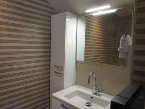 尚帕尼奥勒Hotel de la Londaine的一间带水槽和镜子的浴室