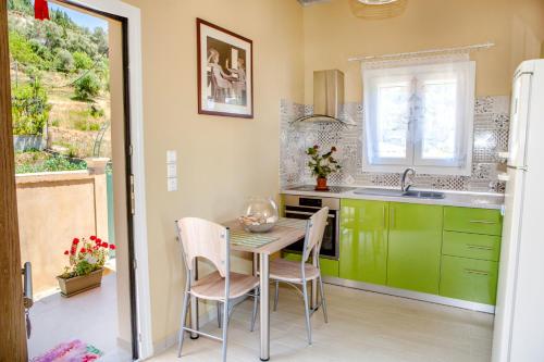 阿齐欧斯·贡多斯FilipposResort的厨房配有绿色橱柜和桌椅