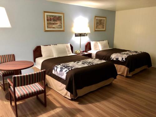 谢里登The Budget Inn Express的酒店客房设有两张床和一张桌子。