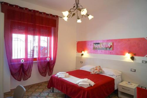 阿杰罗拉Angolo Fiorito的一间卧室设有红色的床和2个窗户。