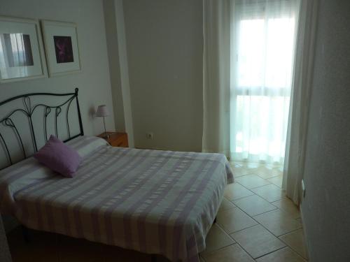 迈阿密普拉特亚JOYAPARTMENTS Gavina D´Or的一间卧室配有一张带紫色枕头的床