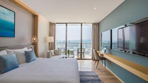 岘港Sel de Mer Hotel & Suites的酒店客房设有一张床和一个大窗户