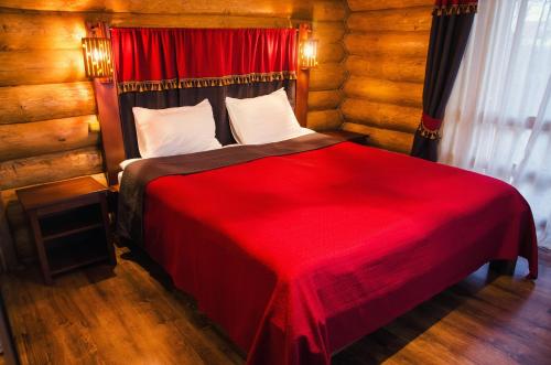 乌日霍罗德普拉哈酒店的一间卧室配有红色的床和红色毯子
