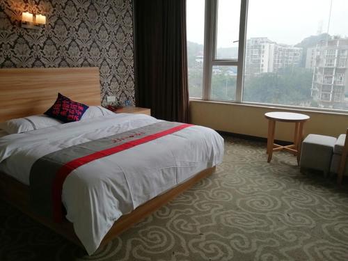 简阳骏怡连锁四川成都简阳简城镇建设路店的酒店客房设有床和窗户。