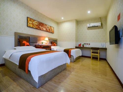 重庆骏怡连锁重庆南岸区南坪东东摩店的酒店客房设有两张床和电视。