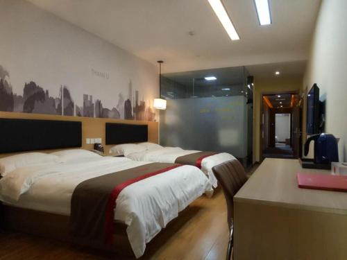 池州尚客优酒店安徽池州站前区火车站店的一间酒店客房,设有两张床和电视