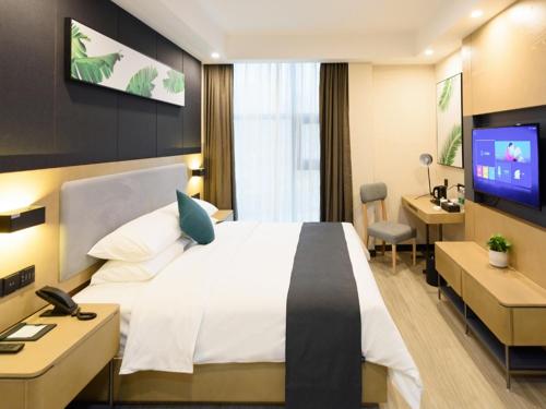 绵阳尚客优品四川绵阳塞纳阳光高铁站店的酒店客房设有一张床、一张书桌和一台电视机。