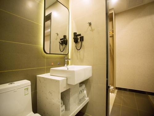 包头尚客优品内蒙古包头青山区中环国际店的一间带水槽、卫生间和镜子的浴室