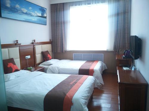 榆林骏怡连锁陕西榆林榆阳区南门汽车站店的酒店客房设有两张床和窗户。