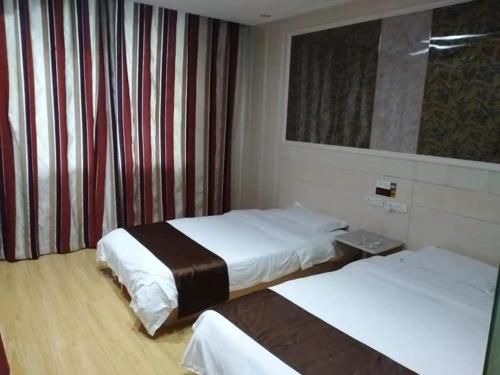 阜阳尚客优酒店安徽阜阳商贸城店的酒店客房设有两张床和窗户。