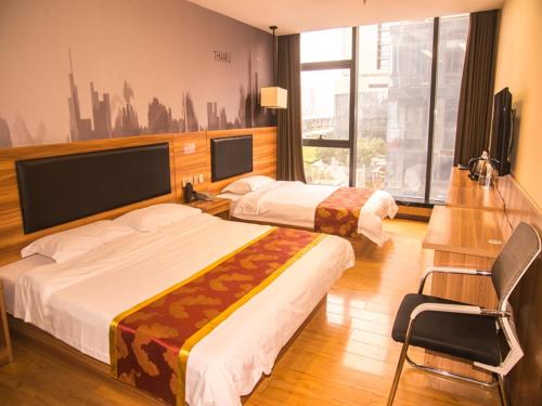郑州尚客优酒店河南郑州郑东新区东站店的酒店客房,配有两张床和椅子