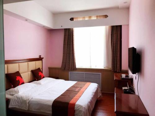 榆林骏怡连锁陕西榆林榆阳区南门汽车站店的一间卧室设有一张大床和一个窗户。