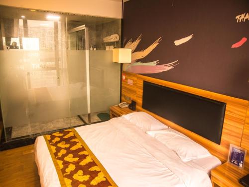 郑州尚客优酒店河南郑州郑东新区东站店的一间卧室配有一张带木制床头板的床