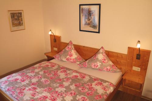 贝希特斯加登威赫拉斯特公寓的一间小卧室,配有一张粉红色的鲜花床